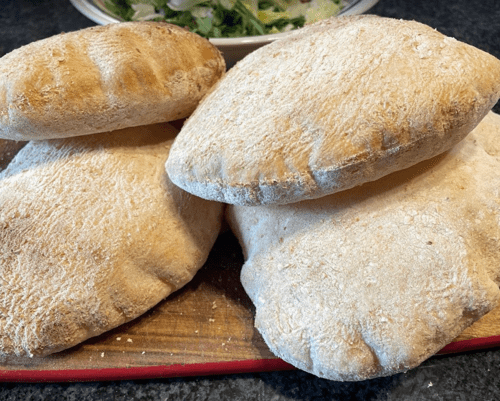 fresh & fluffy traditional pita bread laid on a chopping board